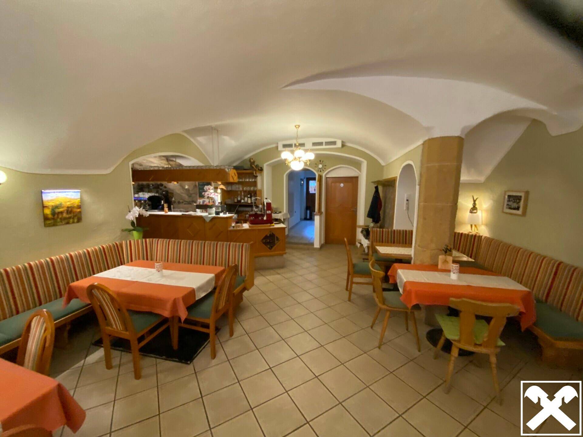 Geräumiger Restaurantbereich mit Gewölbedecken, Sitzbänken und traditioneller Einrichtung.