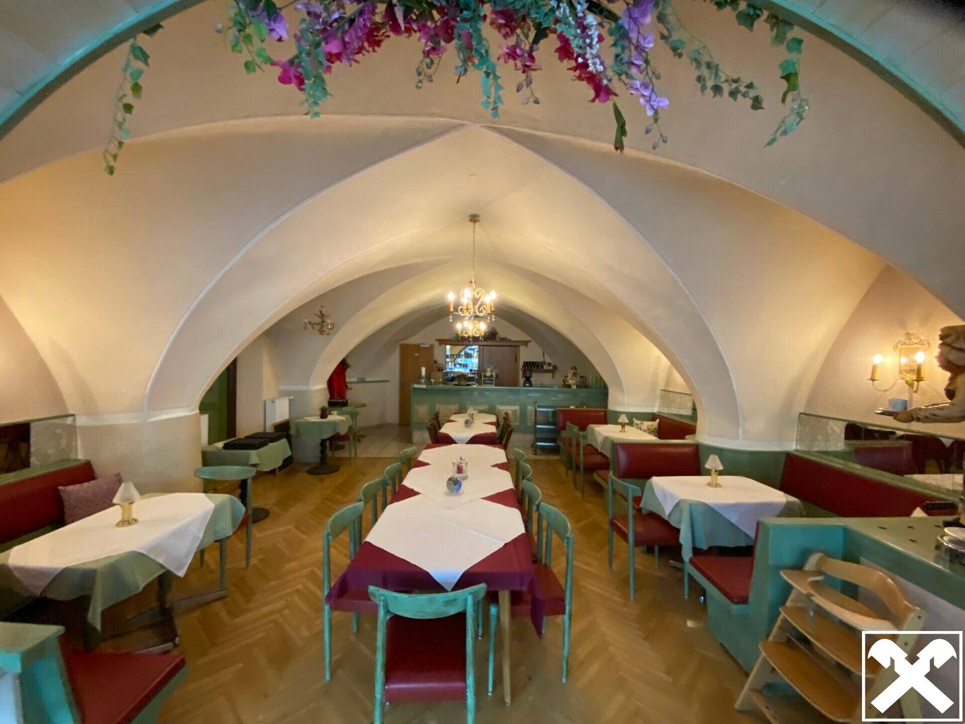 Weitläufiger Restaurantbereich mit eleganten Gewölbedecken, Kronleuchtern und festlich gedeckten Tischen.