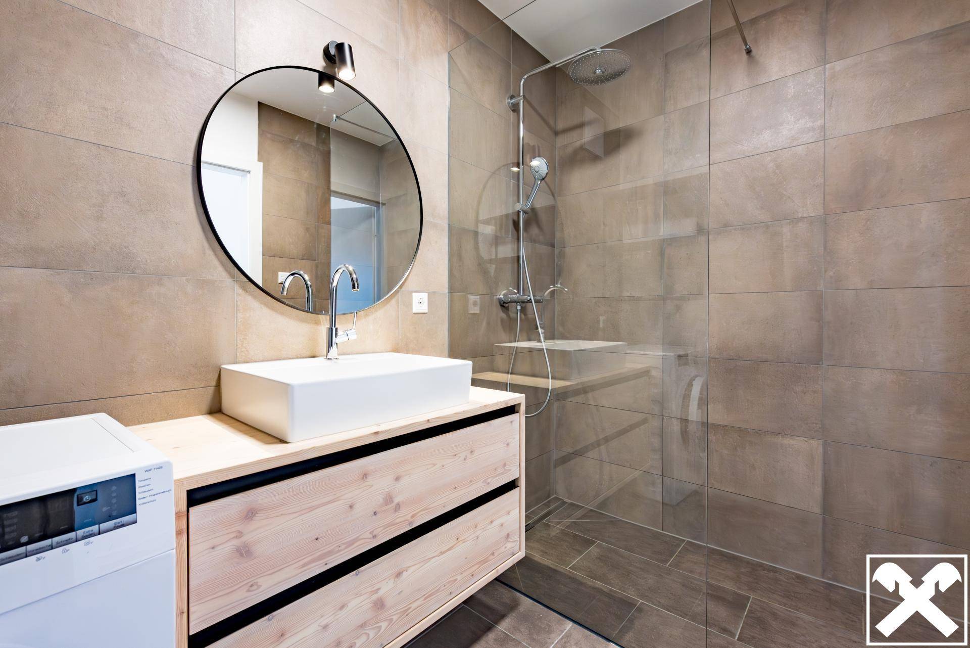 Modernes Badezimmer mit begehbarer Dusche, Holzwaschtisch und großen Fliesen.