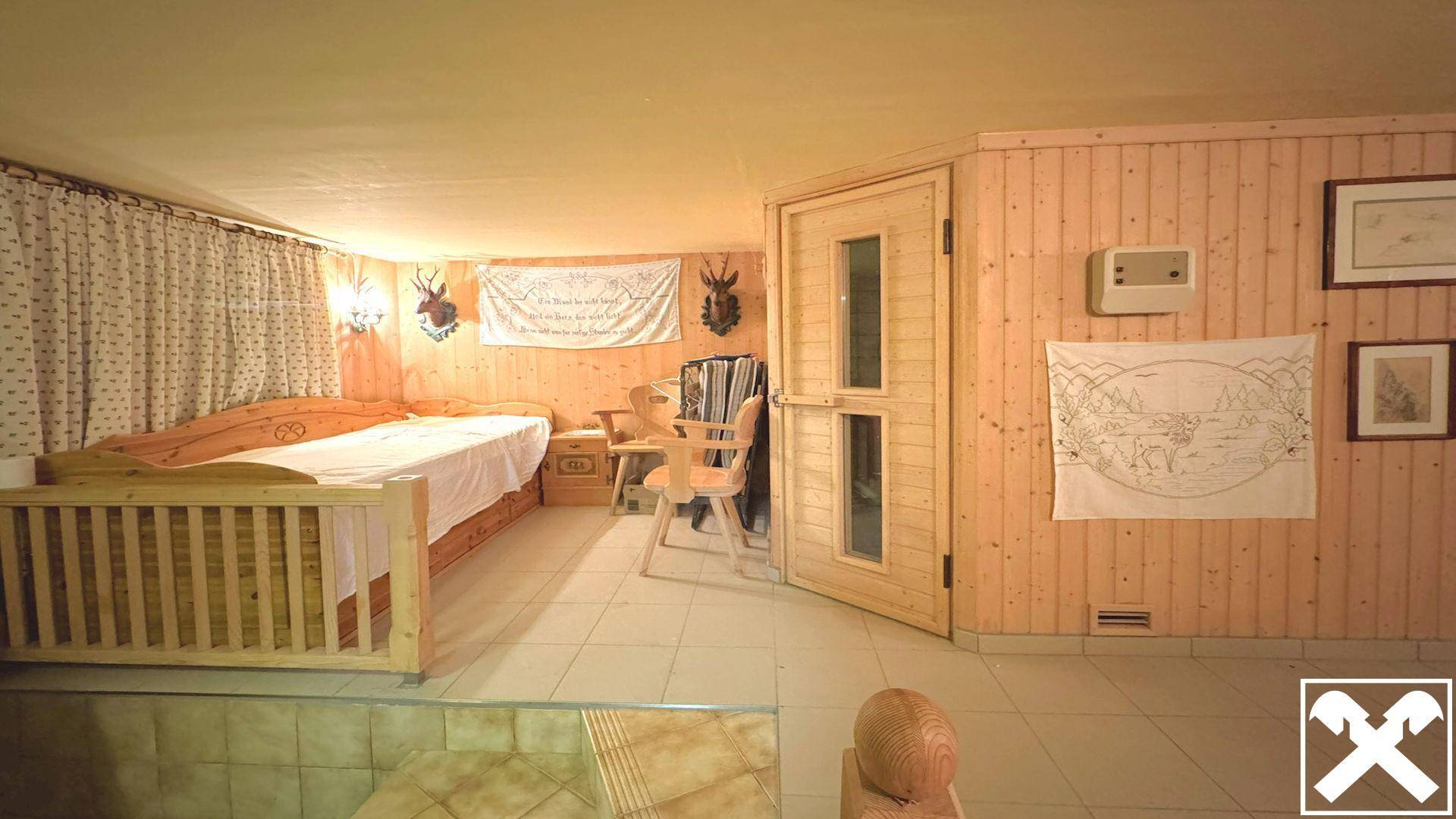 Schlafzimmer im alpinen Stil mit Holzvertäfelung, Fliesenboden und Zugang zu einem Wellnessbereich.