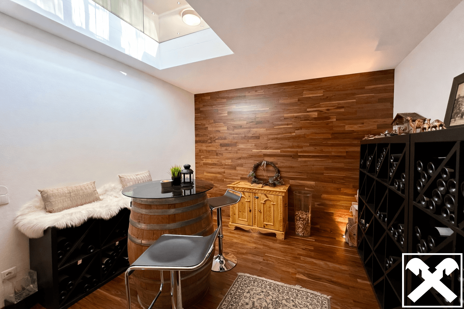 Stilvoller Weinkeller mit Holzvertäfelung, Barhocker und Oberlicht für natürliches Licht.