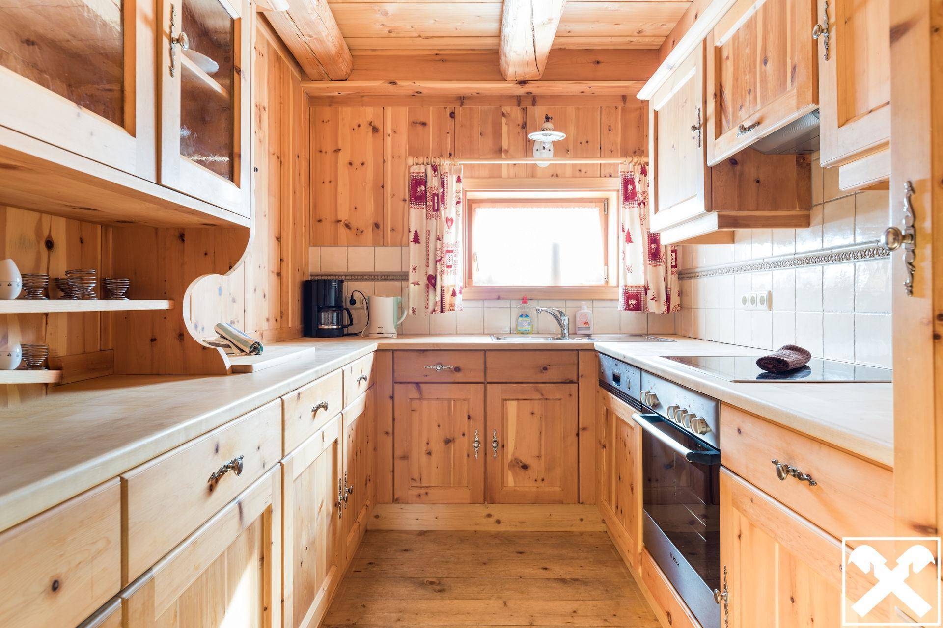 Funktionale Holzküche im Landhausstil mit Einbaugeräten und Fensterblick.
