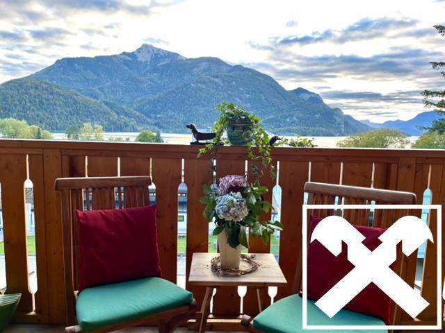 Gemütlicher Balkon mit Holzboden und Sitzgelegenheiten bietet einen atemberaubenden Blick auf den See und die Berge.