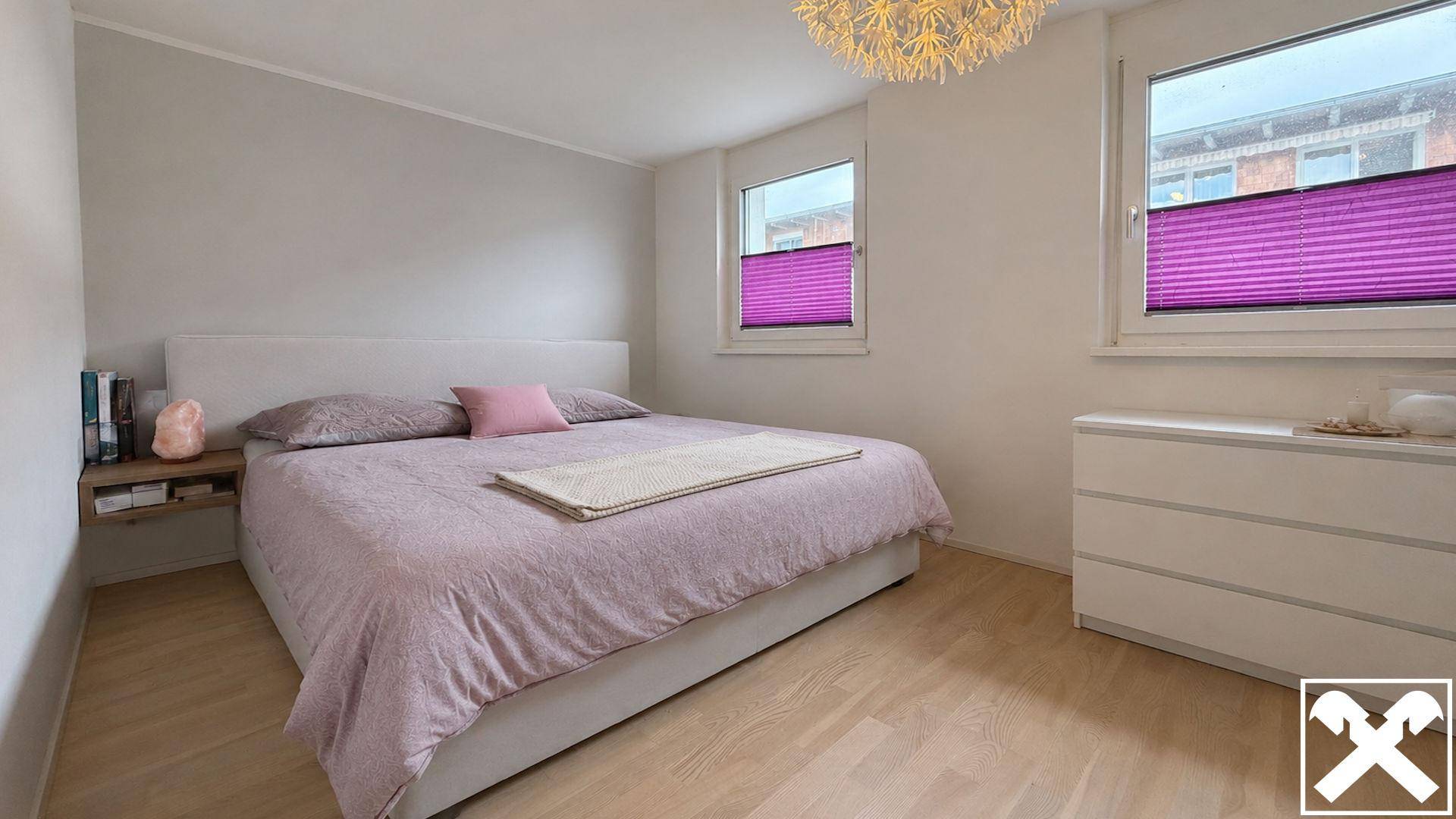 Gemütliches Schlafzimmer mit Doppelbett, Nachttisch und Kommode, ausgestattet mit Holzboden.