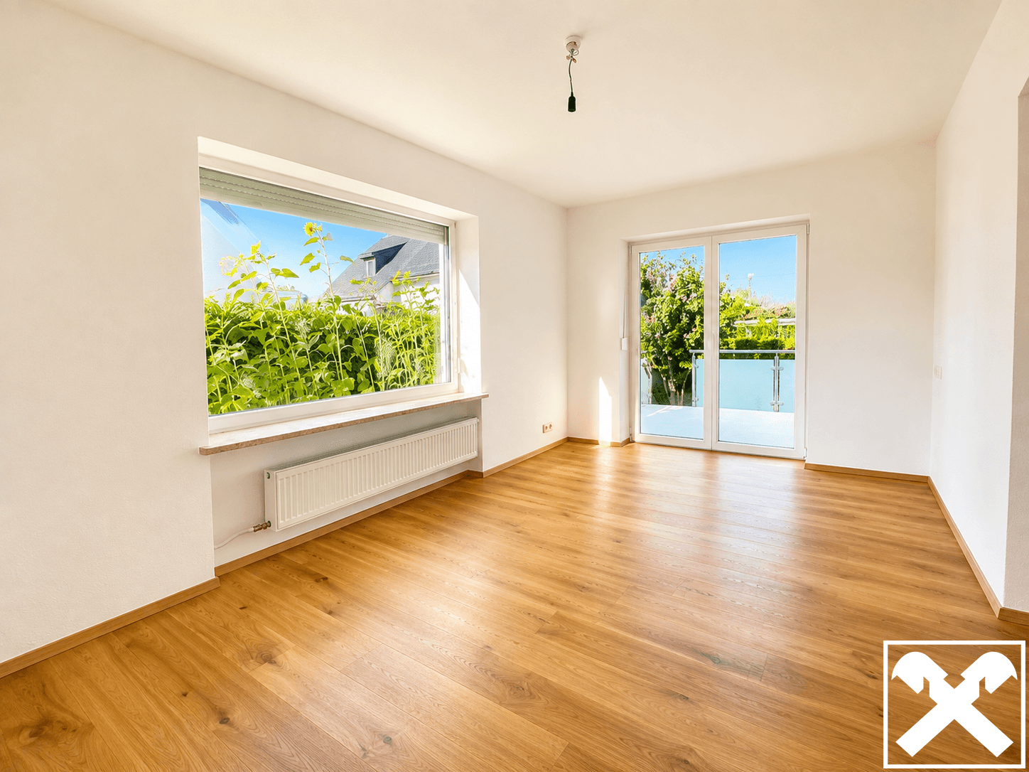 Geräumiges, helles Zimmer mit Laminatboden, großem Fenster und Zugang zum Balkon.