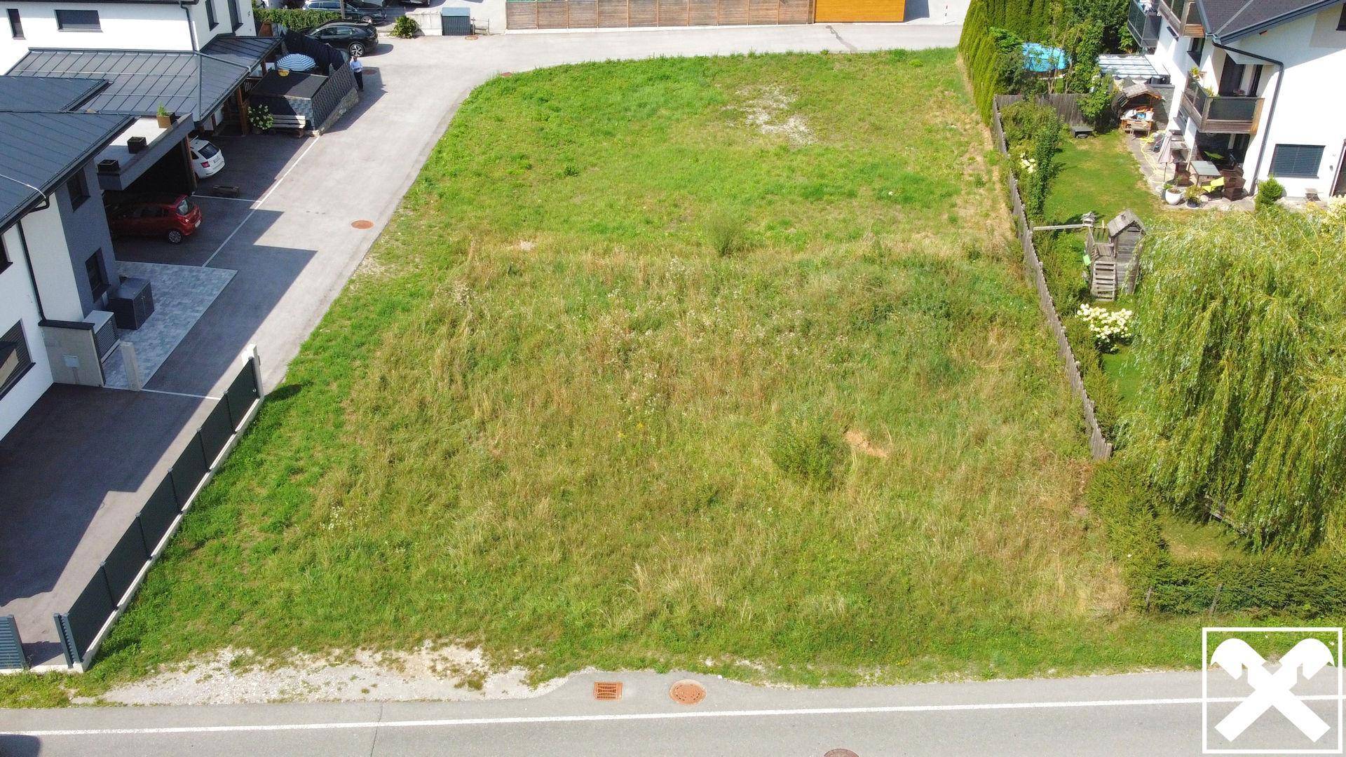 Übersicht des Baugrundstücks von oben, umgeben von Wohnbebauung und Zufahrtsstraßen.