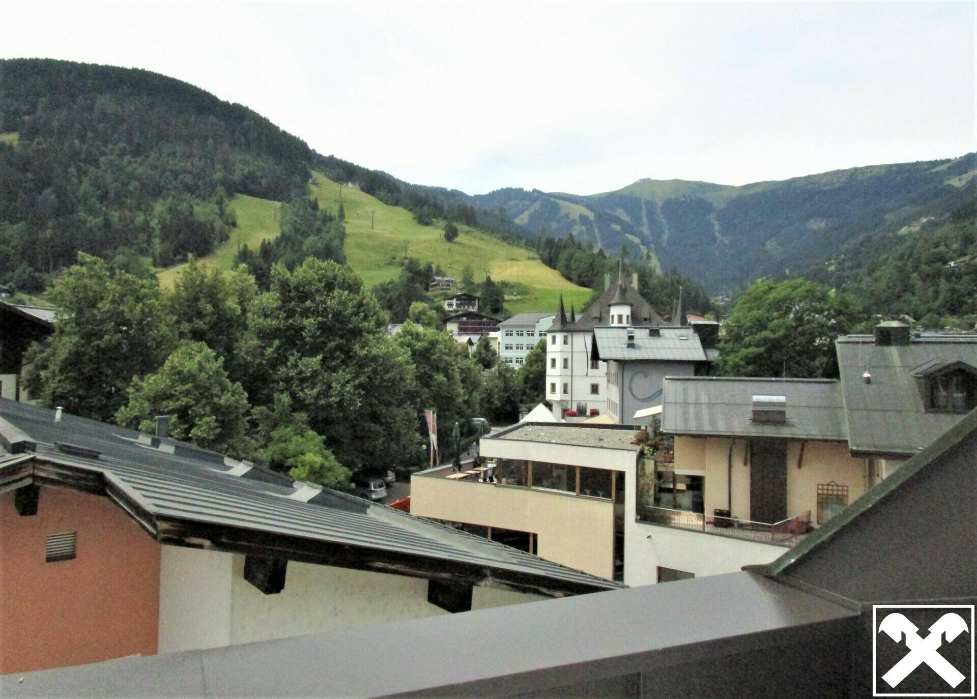 Panoramablick auf die umliegende Berglandschaft und das Dorf mit traditionellen Gebäuden.
