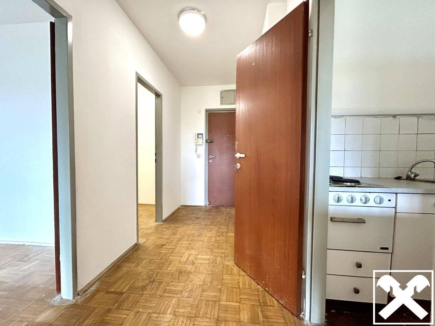 Flur mit Parkettboden und mehreren Türen, die zu verschiedenen Räumen der Wohnung führen.