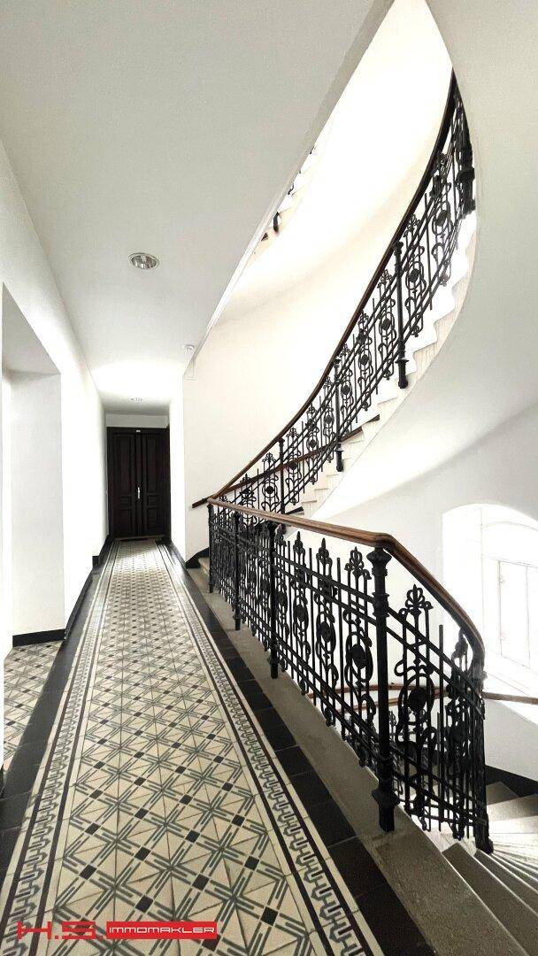 Das elegante Treppenhaus besticht durch ein kunstvolles Geländer und historische Fliesenböden.