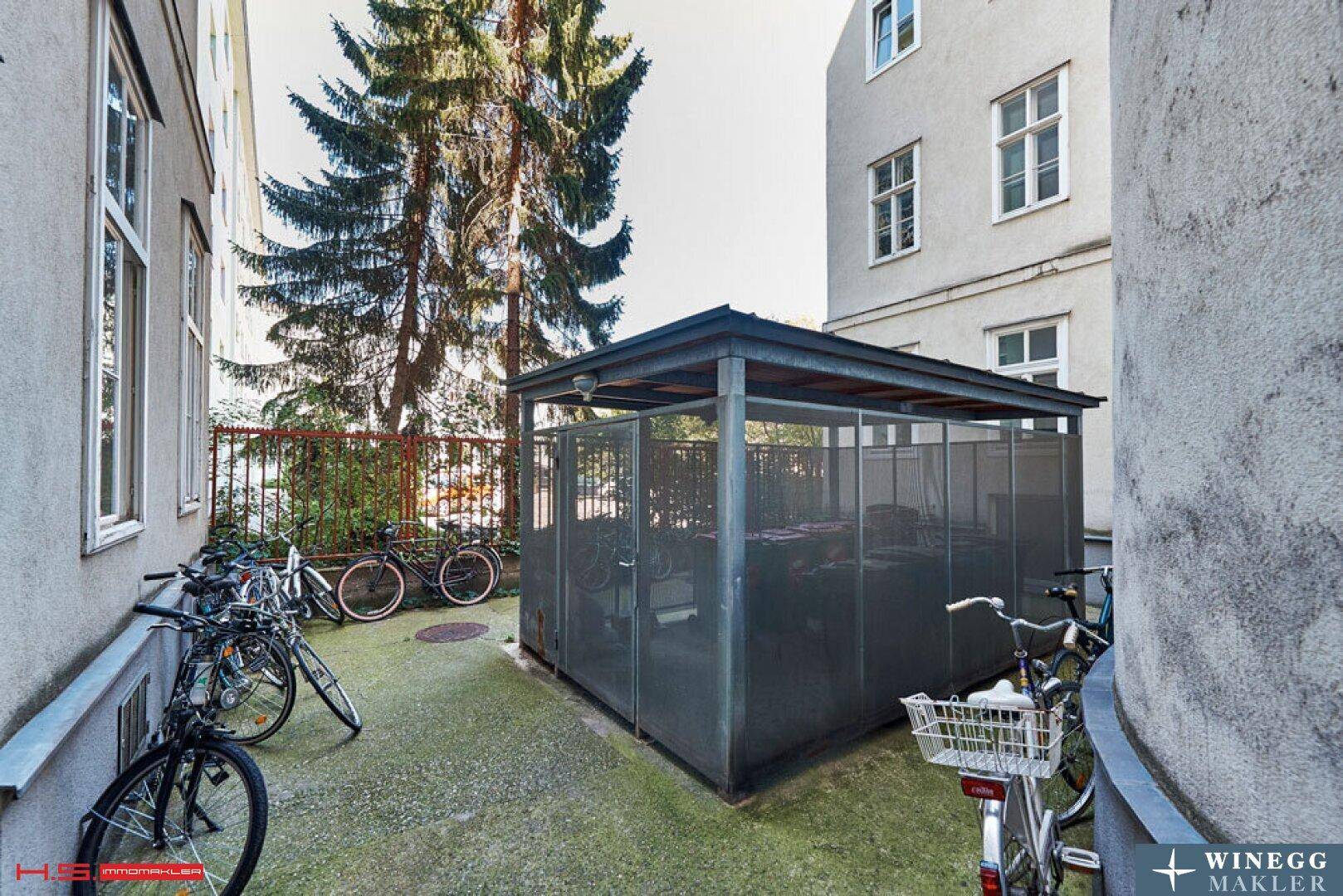 Fahrradabstellplatz im Innenhof zwischen den Gebäuden mit vielen abgestellten Fahrrädern.