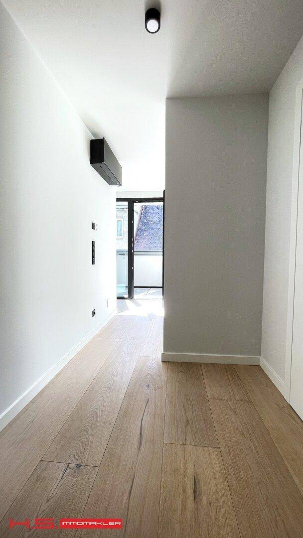Heller Flur mit Holzboden und moderner Klimaanlage an der Wand.