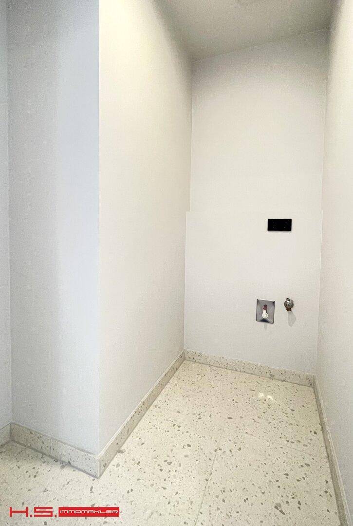 Praktischer Hauswirtschaftsraum mit Fliesenboden und Anschlüssen für Waschmaschine.