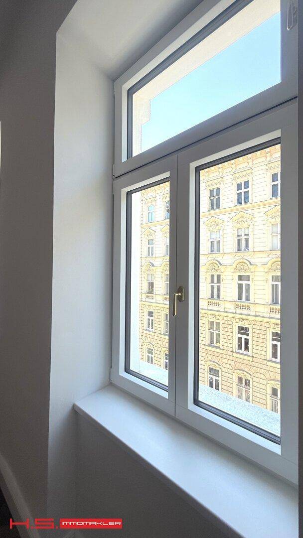 Fenster mit Blick auf die gegenüberliegende historische Gebäudefassade.
