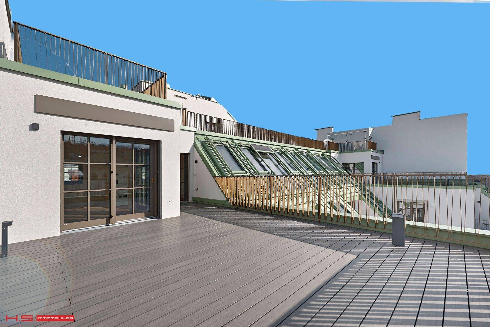 Weitläufige Dachterrasse mit Holzboden und moderner Architektur, die zum Entspannen einlädt.