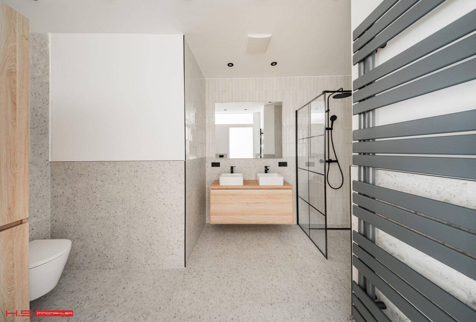 Elegantes Badezimmer mit Doppelwaschbecken, schwebendem Holzwaschtisch und begehbarer Dusche.