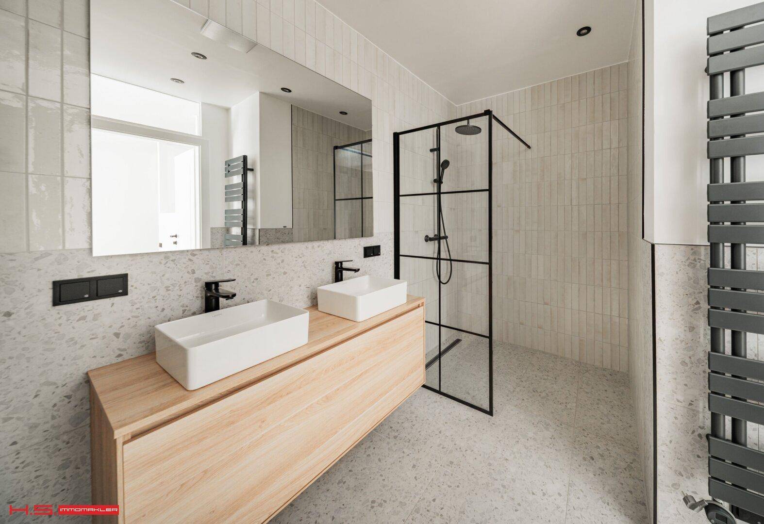 Stilvolles Badezimmer mit Doppelwaschbecken, großem Spiegel und moderner begehbarer Dusche.