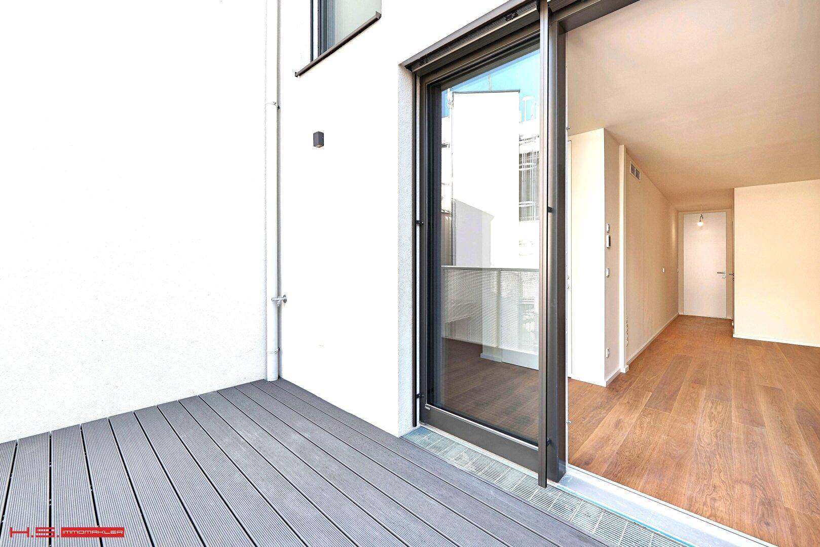 Zugang zu einer Terrasse mit Schiebetür und modernem Bodenbelag, hell und offen.