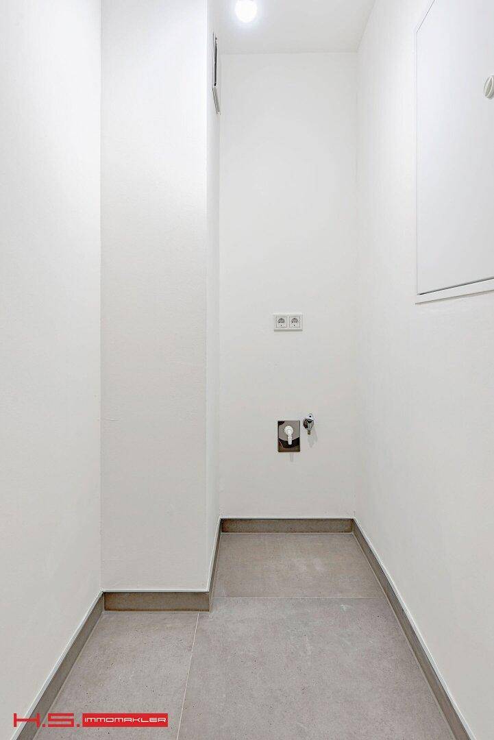 Praktischer Hauswirtschaftsraum mit Fliesenboden und Anschlüssen für Waschmaschine und Trockner.