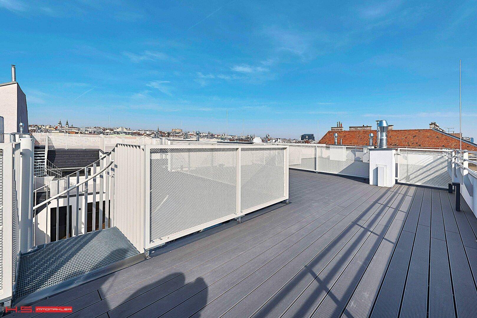 Geräumige Dachterrasse mit Wendeltreppe und weitem Blick über die Stadt.