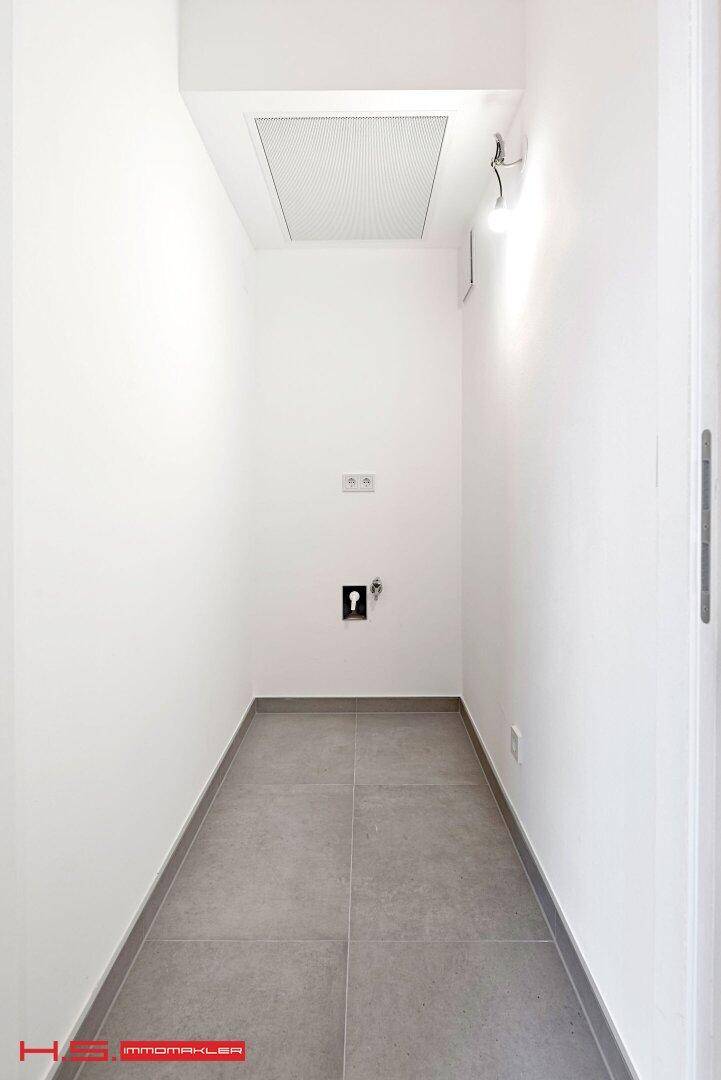 Kleiner Hauswirtschaftsraum mit Fliesenboden und Anschlüssen für eine Waschmaschine.