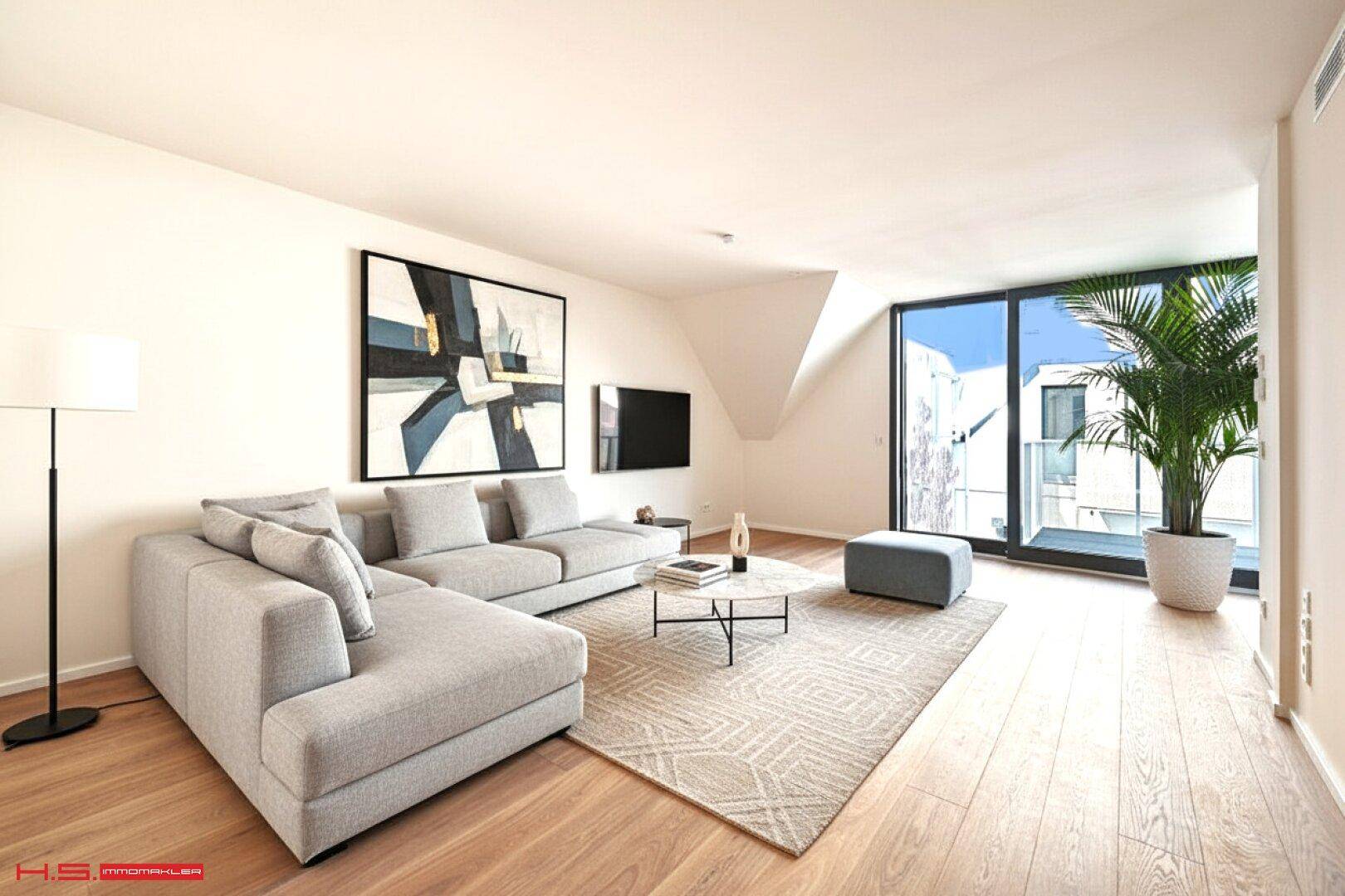 Modernes Wohnzimmer mit Ecksofa, Holzboden und Zugang zu einem Balkon.