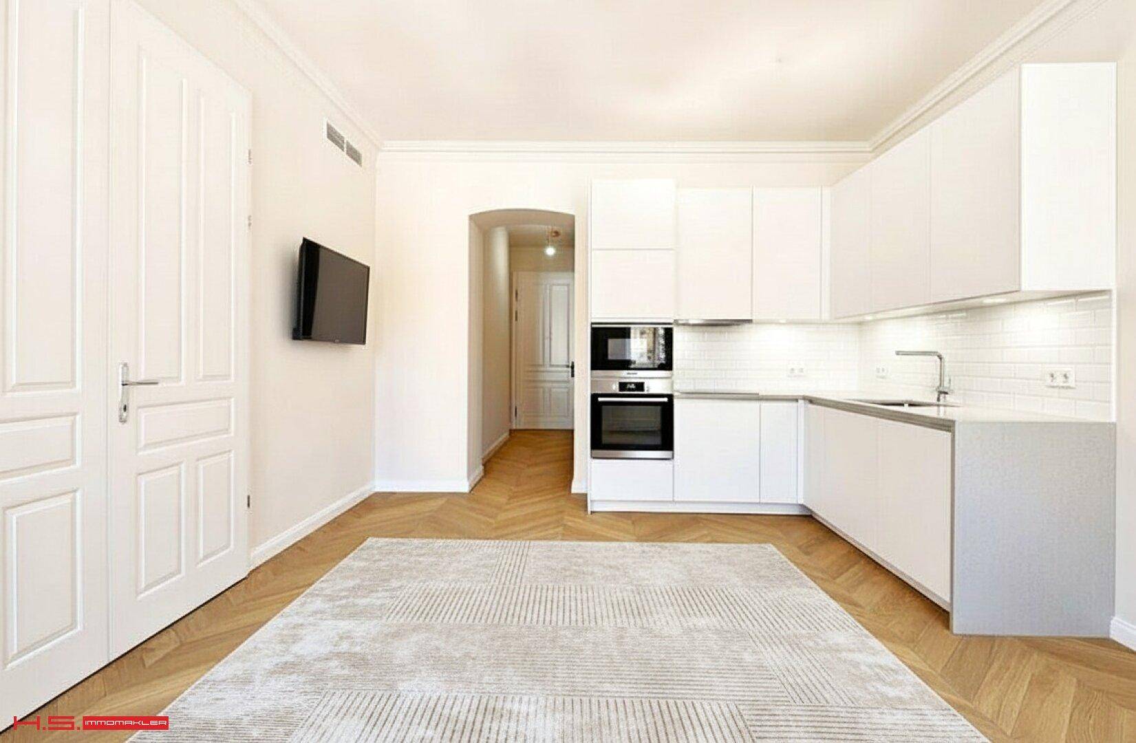 Moderne, helle Küche mit weißen Schränken, Holzboden und integrierten Geräten.