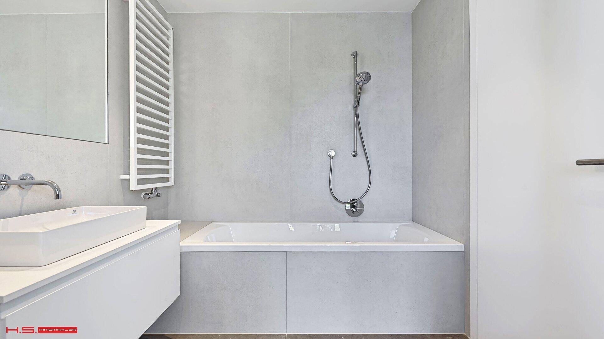Elegantes Badezimmer mit integrierter Badewanne, Duschfunktion und beheiztem Handtuchhalter.