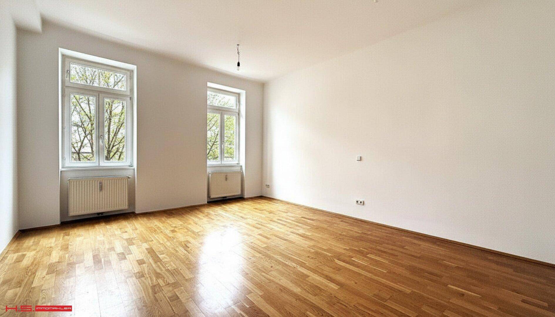 Geräumiges, helles Zimmer mit Parkettboden und zwei großen Fenstern, bereit zur individuellen Gestaltung.