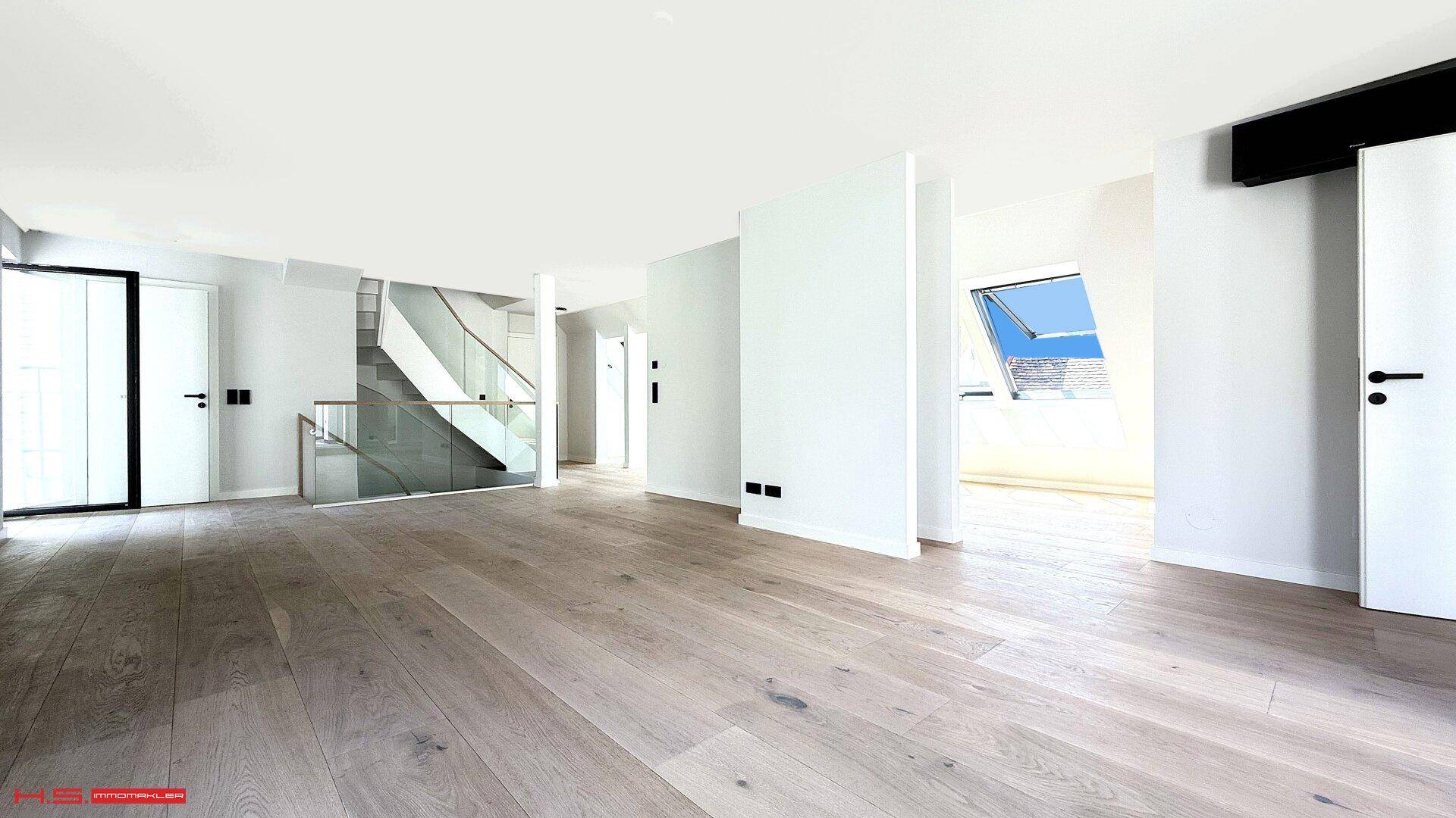 Offener Wohnbereich mit moderner Treppe, Holzboden und viel natürlichem Licht durch Dachfenster.