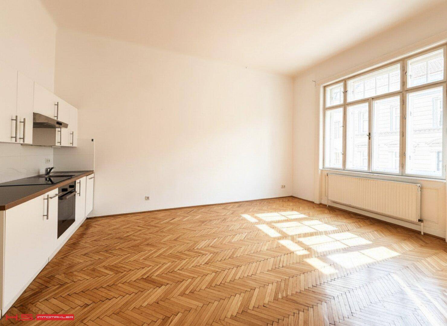 Helle Küche mit Fischgrätparkett, Einbauküche und viel Tageslicht.