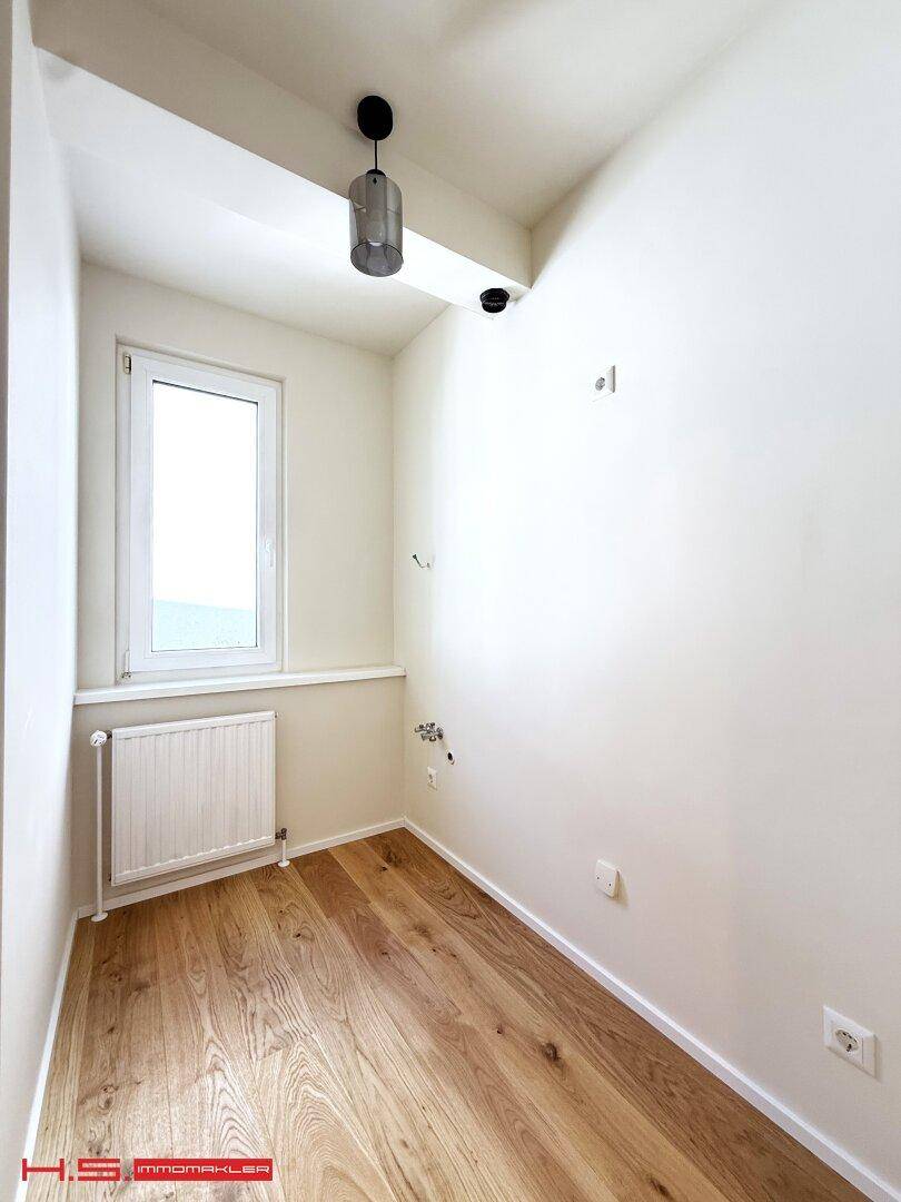 Kleiner Hauswirtschaftsraum mit Fenster und Holzboden, vielseitig nutzbar.