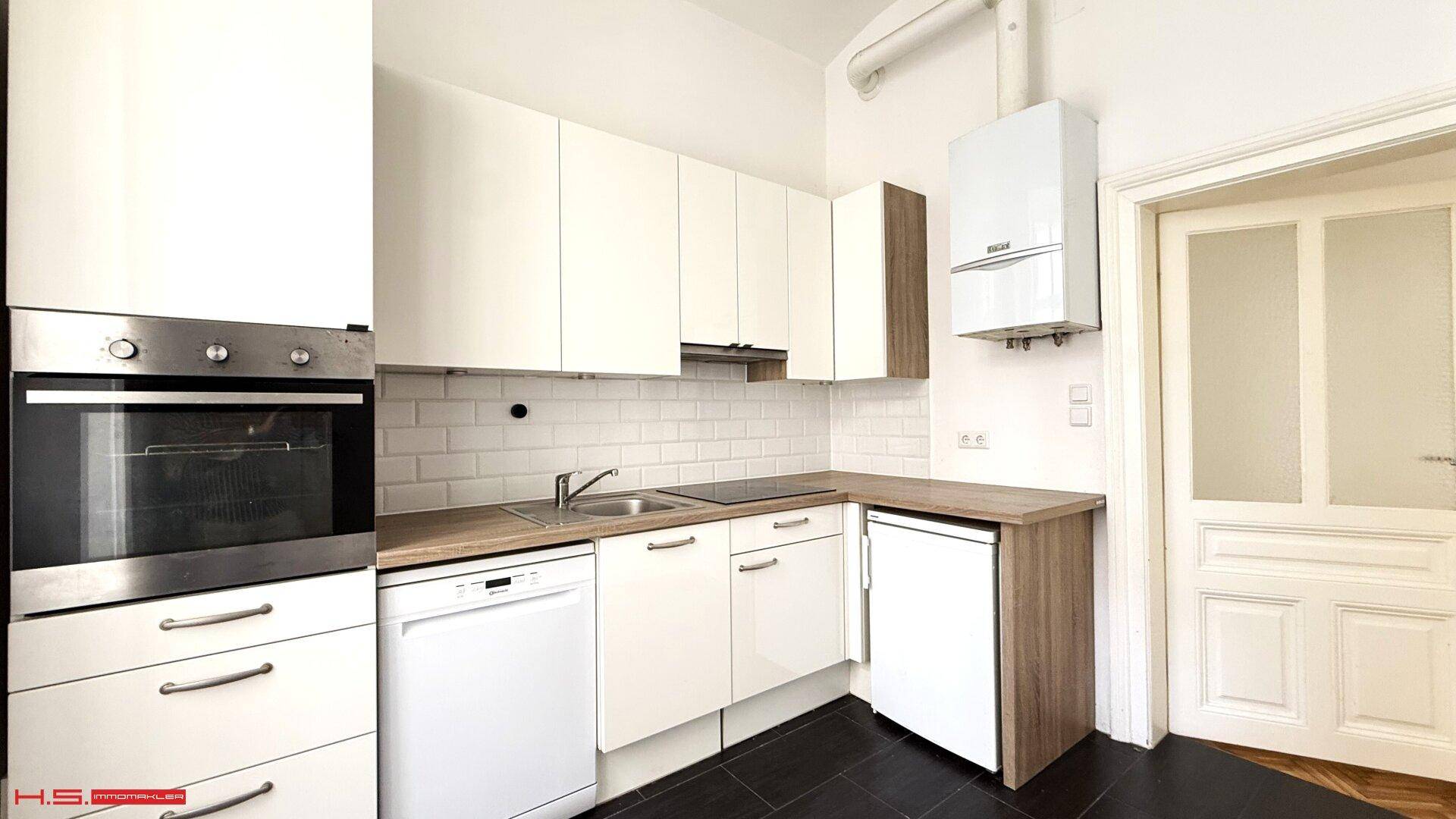 Moderne Einbauküche mit weißen Schränken, integrierten Geräten und Gastherme.