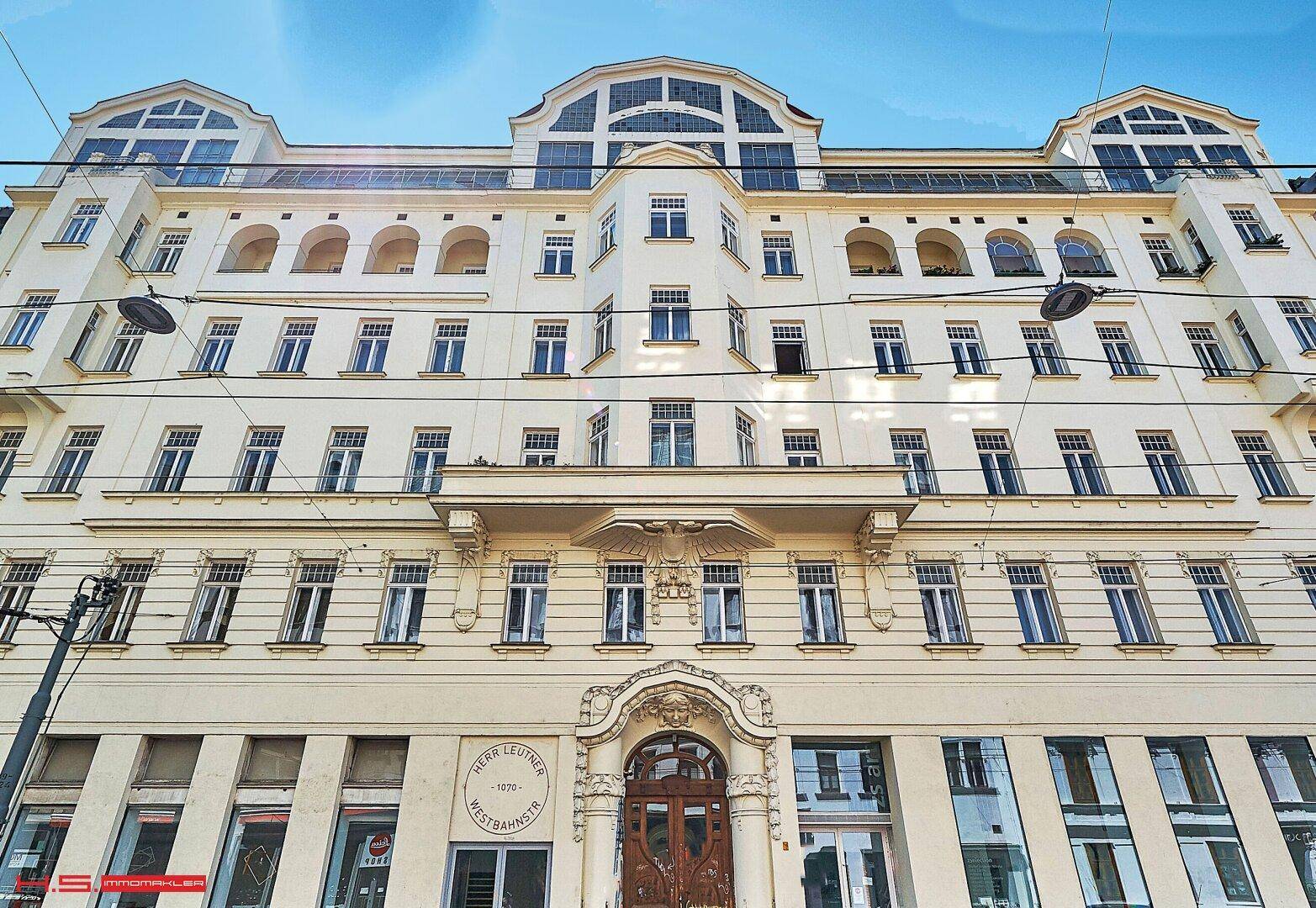 Elegante Fassade eines historischen Gebäudes mit vielen Fenstern und Balkonen.