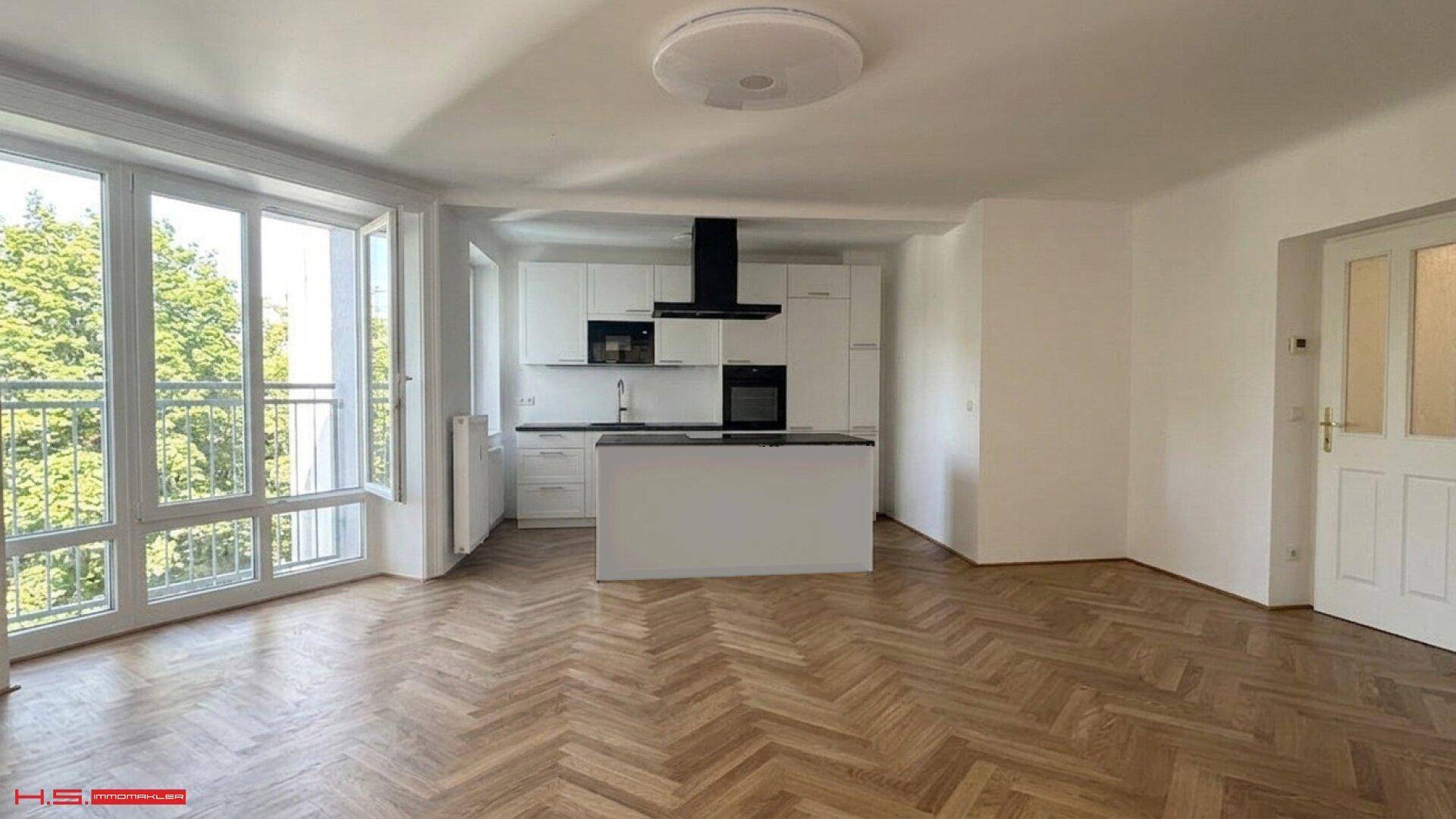 Geräumiger offener Wohn-Essbereich mit integrierter Küche, Fischgrätparkett und viel Tageslicht durch große Fenster.