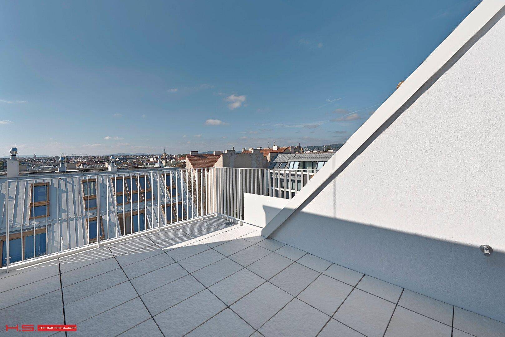 Weitläufige Dachterrasse mit Panoramablick über die Stadt und die umliegende Landschaft.