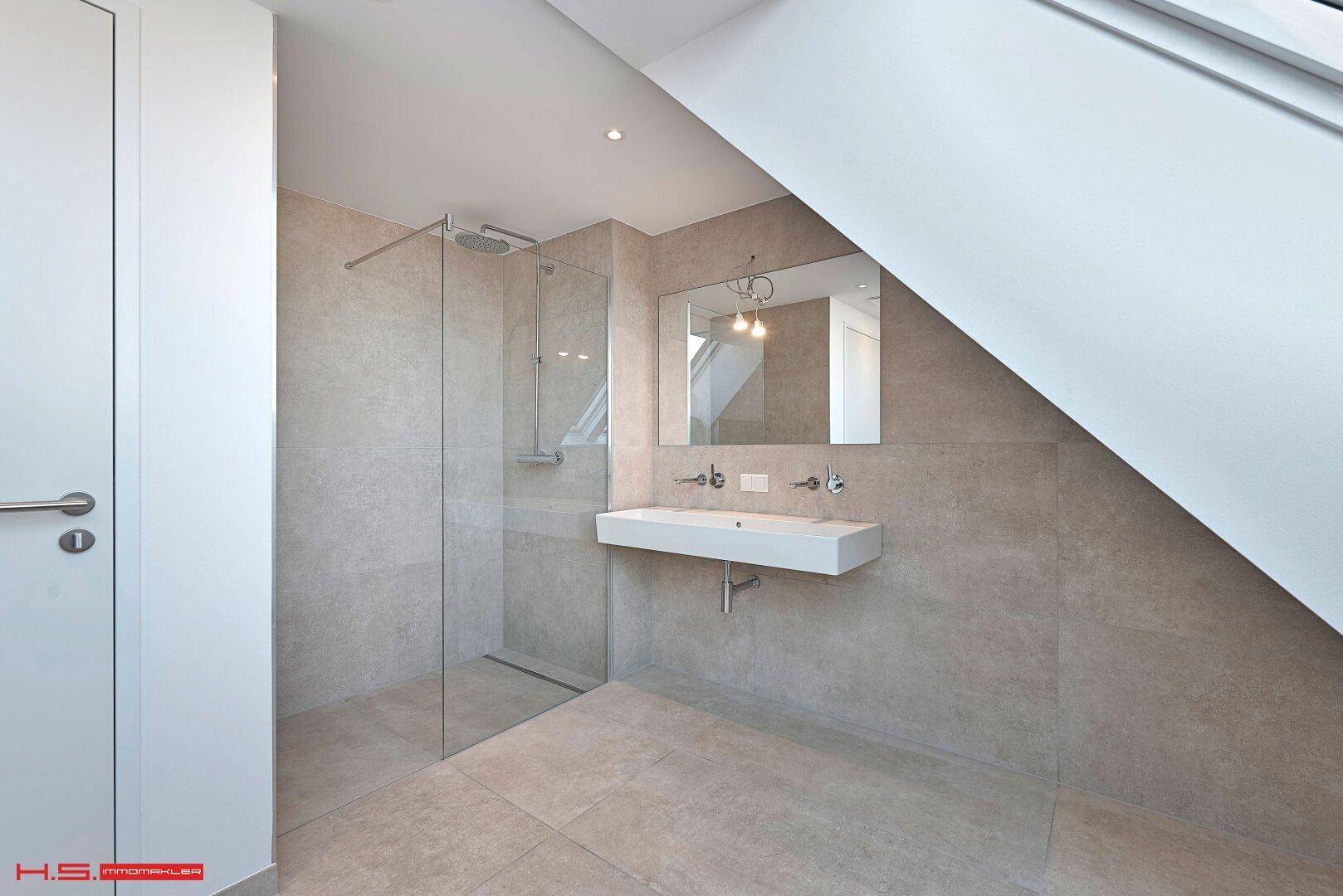 Elegantes Badezimmer im Dachgeschoss mit begehbarer Dusche und modernem Waschtisch.