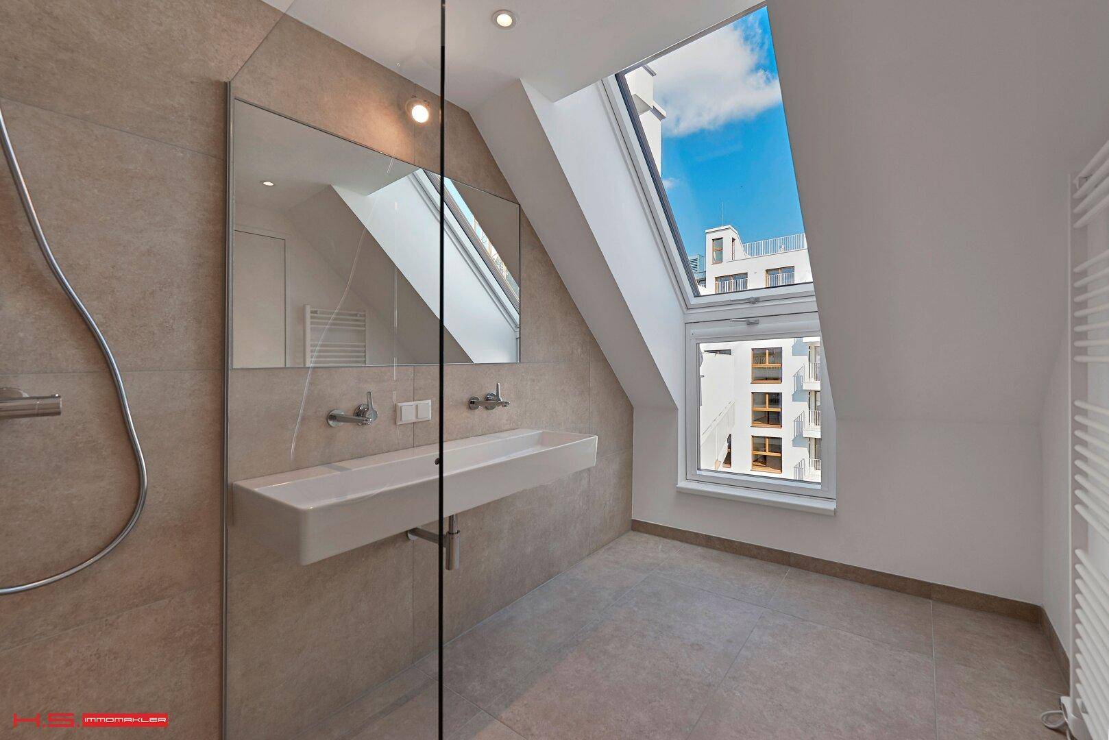 Modernes Badezimmer mit begehbarer Dusche, Dachfenster und beheiztem Handtuchhalter.
