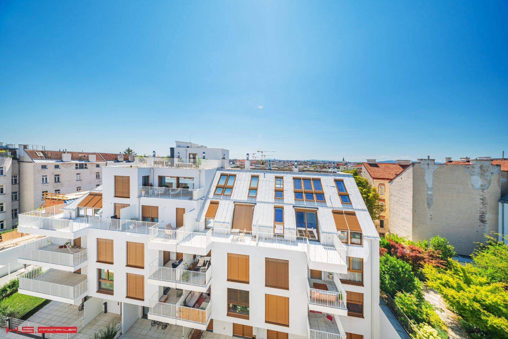Moderne Wohnanlage mit mehreren Balkonen und Terrassen in urbaner Umgebung.