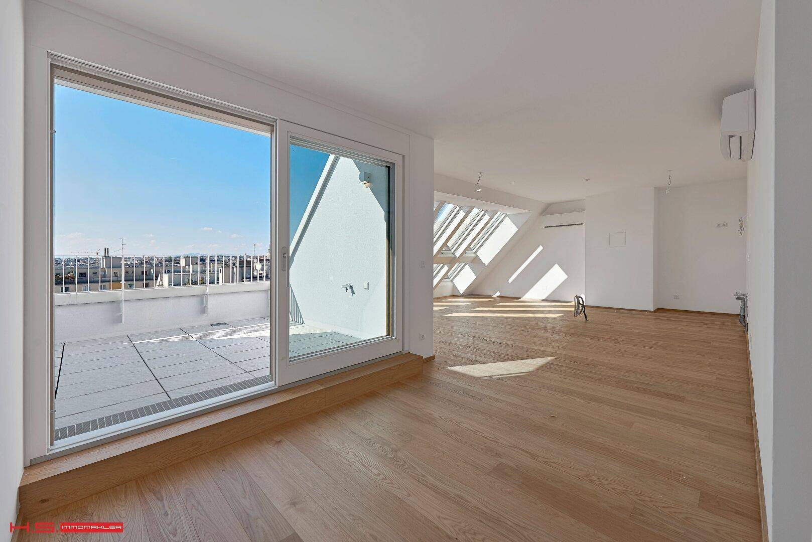 Lichtdurchfluteter Wohnbereich mit großen Schiebetüren zur Terrasse und Holzboden.