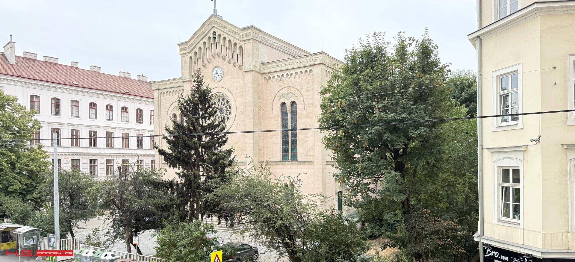 Blick auf eine historische Kirche und die umliegende Stadtlandschaft mit Bäumen.