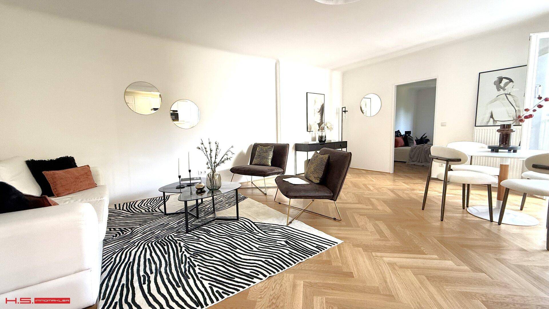 Heller Wohnbereich mit bequemen Sofas, modernem Teppich und stilvoller Dekoration.