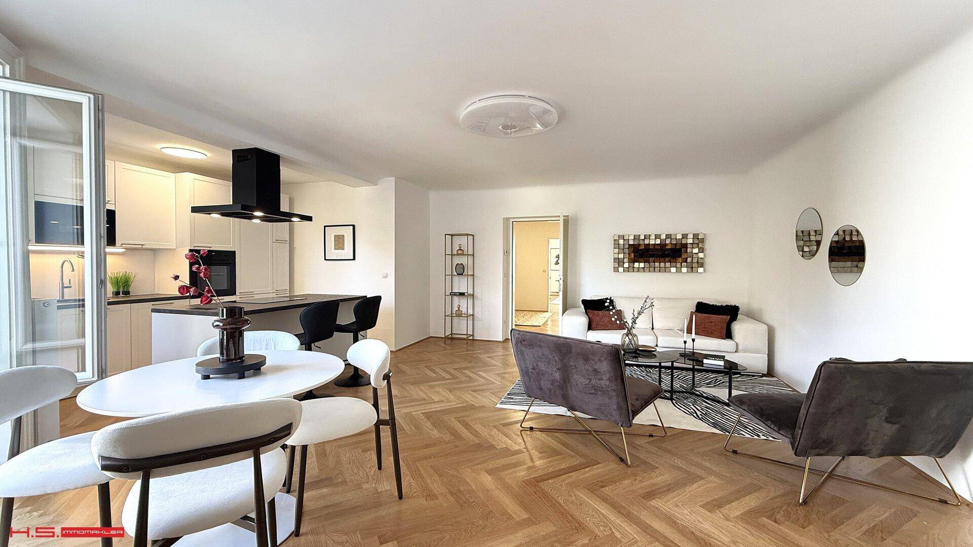 Weitläufiger offener Wohnbereich mit integrierter Küche und Essplatz, ideal für geselliges Beisammensein.