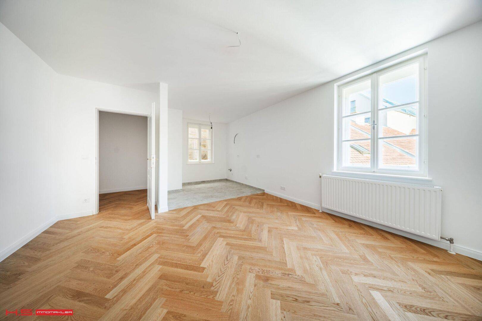 Geräumiges Zimmer mit neu verlegtem Fischgrätparkett und hellen Wänden, bereit zur Gestaltung.