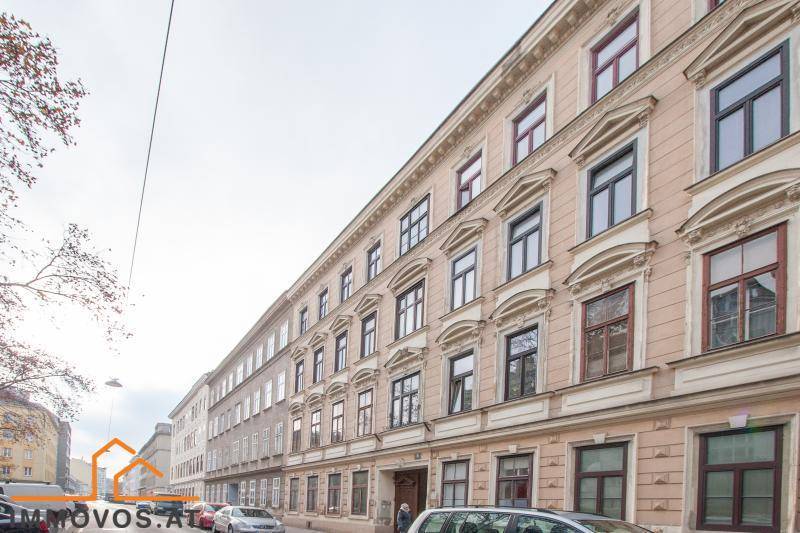 Historische Fassade eines Mehrfamilienhauses an einer städtischen Straße.