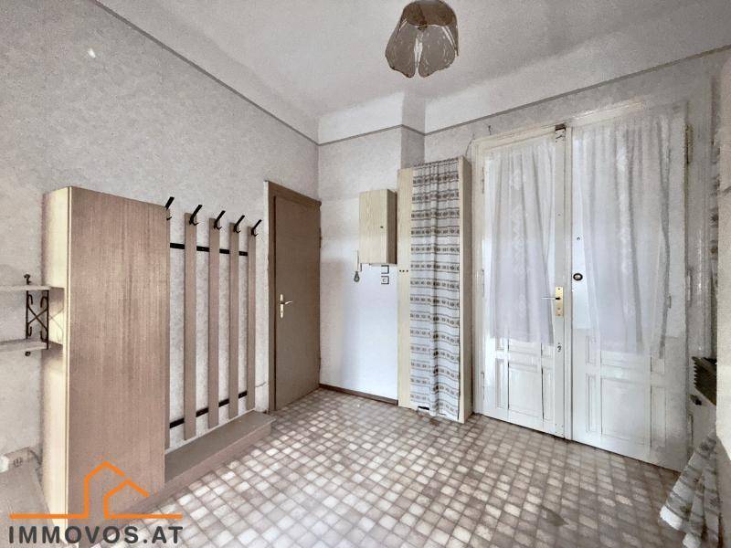 Geräumiger Flur mit gemustertem Fliesenboden und Garderobe.