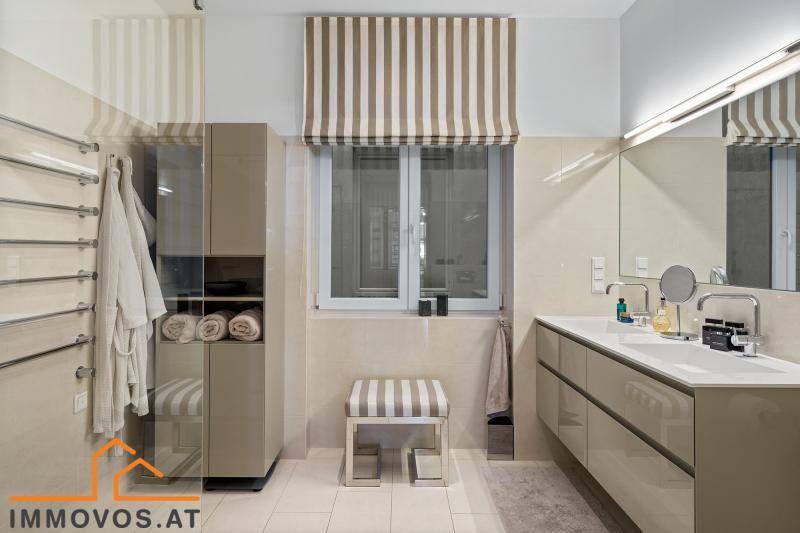 Modernes Badezimmer mit Doppelwaschbecken, begehbarer Dusche und beheiztem Handtuchhalter.