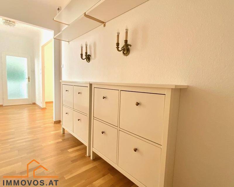 Heller Flur mit praktischen Schuhschränken und dekorativen Wandleuchten, die eine einladende Atmosphäre schaffen.