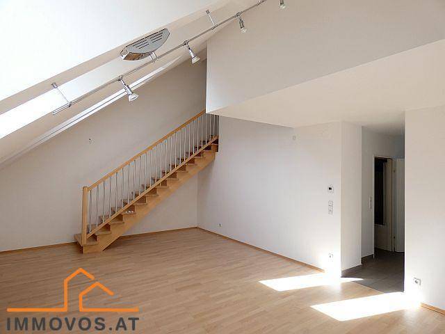 Geräumiger Wohnbereich im Dachgeschoss mit Holztreppe, Parkettboden und viel Tageslicht.