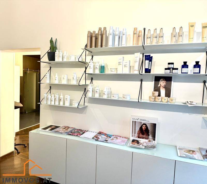 Verkaufsregal im Salon mit einer Auswahl an Haarpflegeprodukten und Zeitschriften für Kunden.