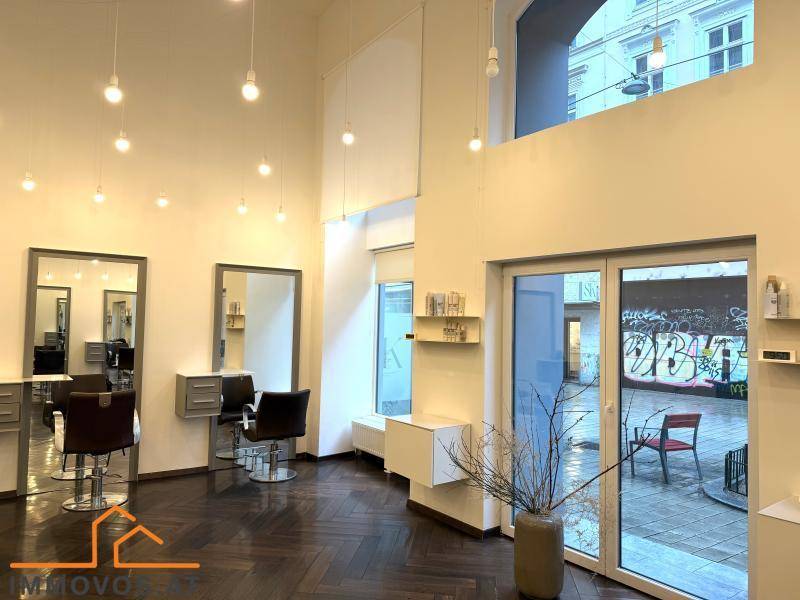 Moderner Friseursalon mit Blick auf die Straße, hohen Decken und stilvollem Fischgrätparkett.